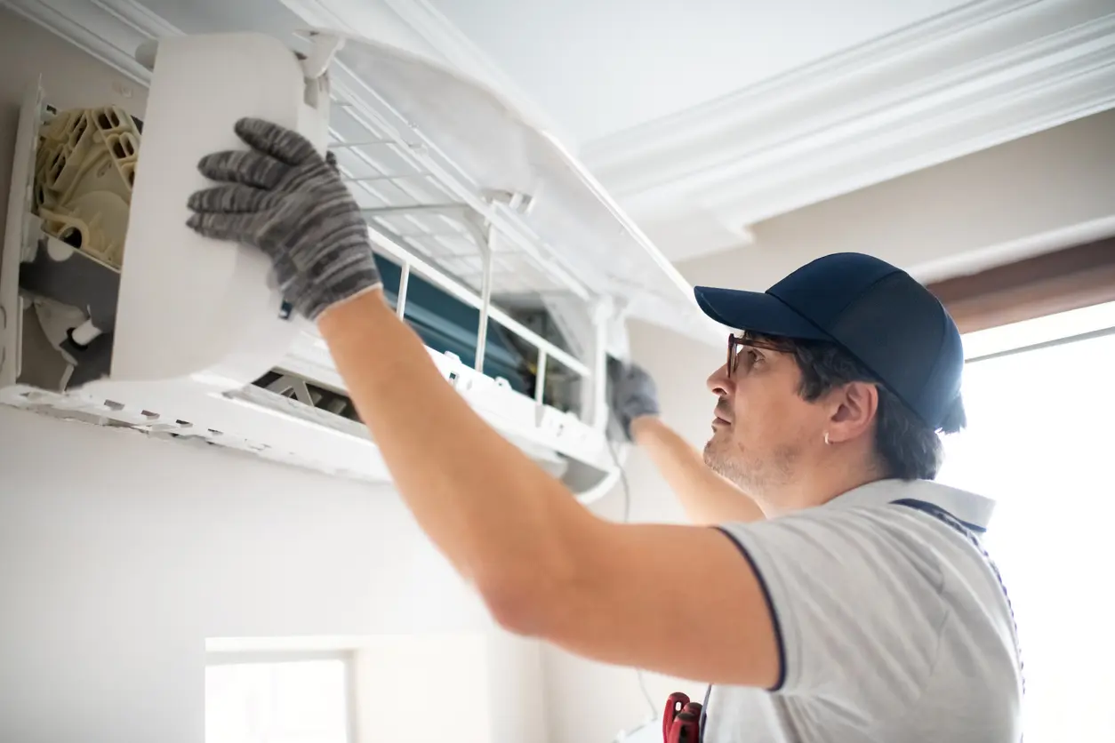 Technician repairing air conditioner at home